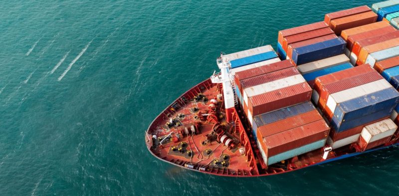 aerial-side-view-of-cargo-ship-carrying-container-and-running-for-export-goods-from-cargo-yard.jpg